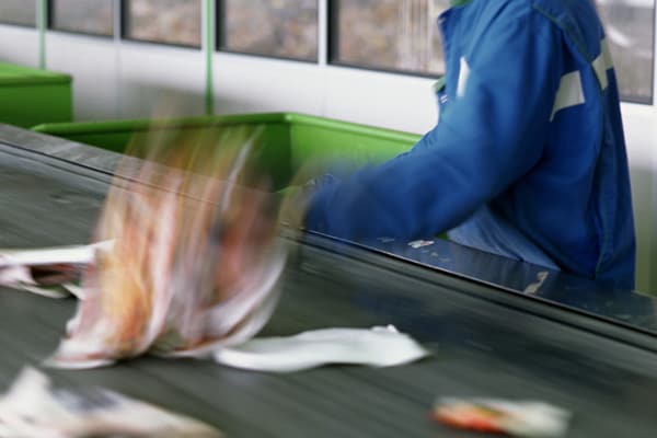 Worker sorting recyclables on a conveyor belt